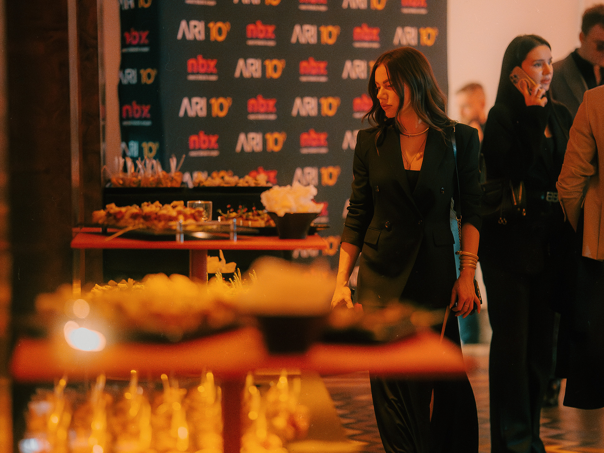Bankiet firmowy w Messalka Events – goście przy stole z finger foodem, ścianka z logo klienta